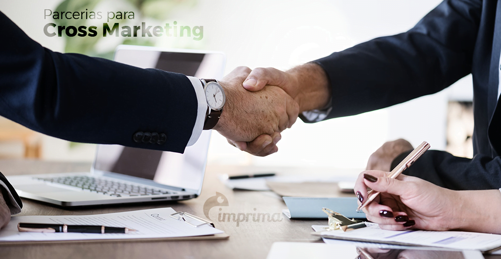 Duas mãos, aparentemente de dois empresários, apertando uma a outra, demonstrando parceria e/ou fechamento de negócios.