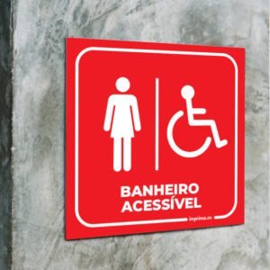 Imagem que ilustra um modelo de placa de sinalização interna para banheiro feminino acessível, fabricada em PS pela Imprima.vc, de fundo azul, aplicada em parede.