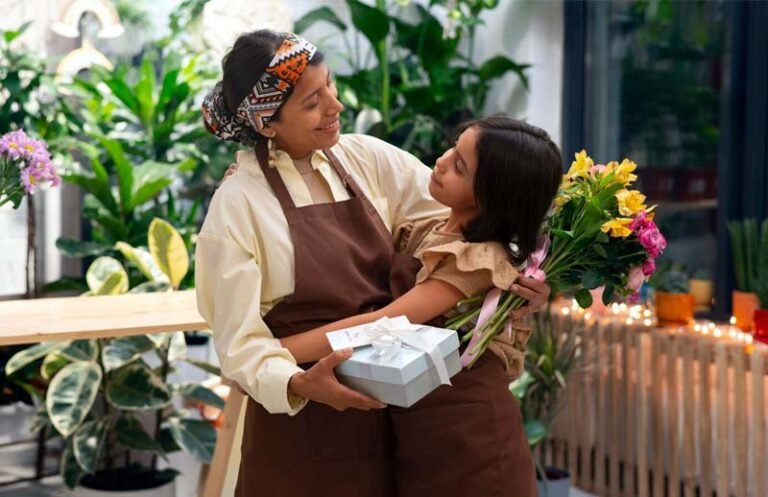 Mãe e filha se abraçando e trocando presente em uma loja da família, simbolizando a importância do Dia das Mães para o pequeno comercio. simbolizando a impor